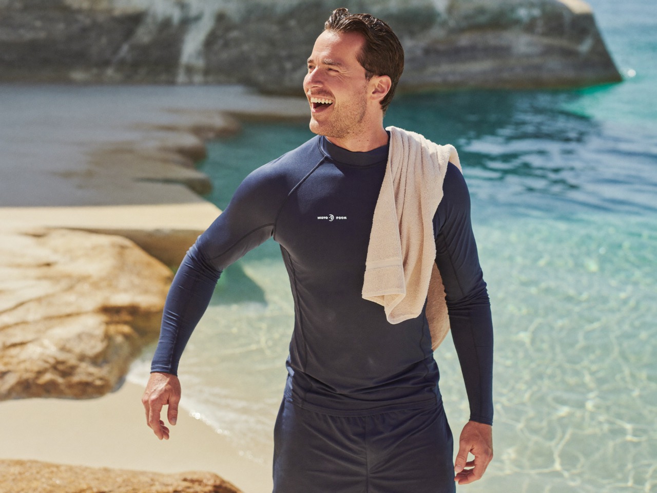 A man in his thirties walking out of an ocean rock pool after a morning swim